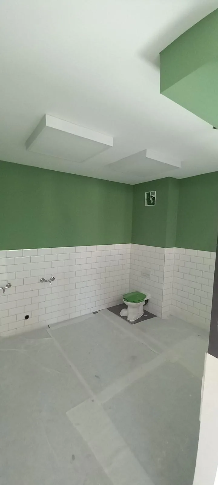 Salle de bain aux murs vert sauge et faïence métro blanche