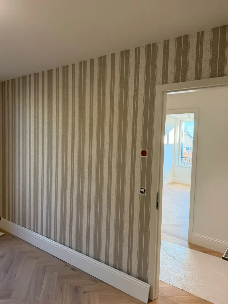 Papier peint à rayures dans un couloir au parquet en chevrons