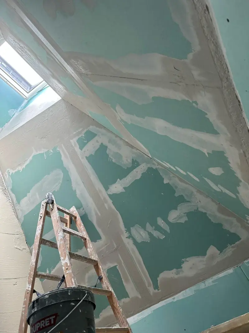 Plafond en plaques hydrofuges avec bandes de joints lissées